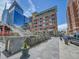 Street-level view of building exterior near restaurants and a pedestrian bridge at 2100 16Th St # 204, Denver, CO 80202