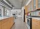 Open kitchen with stainless appliances, light wood cabinetry, and industrial-style ceiling at 2100 16Th St # 204, Denver, CO 80202