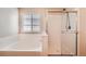 Bathroom featuring bathtub and stand-up shower with transparent door next to a window at 560 Hampstead Ave, Castle Rock, CO 80104