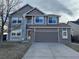 Two-story house with gray siding, a large driveway, and landscaping at 560 Hampstead Ave, Castle Rock, CO 80104