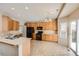 Well-lit kitchen features wood cabinets, tile floors, black appliances, and access to the backyard at 560 Hampstead Ave, Castle Rock, CO 80104