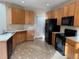 Kitchen with light wood cabinets, black appliances, and tile floors at 560 Hampstead Ave, Castle Rock, CO 80104