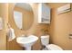 Cozy powder room features a pedestal sink, toilet, decorative mirror, and cabinetry at 6232 W Cross Dr, Littleton, CO 80123