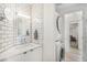 Modern bathroom featuring subway tile, a vanity, and stackable washer/dryer units at 180 Cook St # 406, Denver, CO 80206