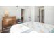 Well-lit bedroom featuring neutral tones, patterned bedding, and a vintage dresser with decorative lamp at 180 Cook St # 406, Denver, CO 80206