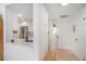 Bright entryway featuring a modern white door, hardwood floors, and a view of the kitchen at 180 Cook St # 406, Denver, CO 80206