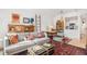 Well-lit living room with sofa, desk, and vintage decor plus an adjoining view of the kitchen at 180 Cook St # 406, Denver, CO 80206