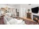 Cozy living room featuring a fireplace, modern sofa, and an adjacent view into the updated kitchen at 180 Cook St # 406, Denver, CO 80206