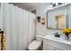 Bathroom featuring tiled shower with a shower curtain, white vanity, and decorative shelves at 1641 S Parfet Ct, Denver, CO 80232