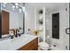 Modern bathroom featuring stylish fixtures, marble countertop, and a glass-enclosed shower with black accents at 1641 S Parfet Ct, Denver, CO 80232
