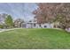 Well-maintained home exterior featuring a green lawn, mature trees, and a gray exterior at 1641 S Parfet Ct, Denver, CO 80232