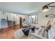Bright living room featuring hardwood floors, a large bay window, and comfortable seating at 1641 S Parfet Ct, Denver, CO 80232