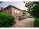Back exterior of home with brick accents, a ramp, patio area, and lush landscaping at 3231 Oak St, Wheat Ridge, CO 80033