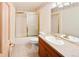 Cozy bathroom with a vanity, mirrored medicine cabinet, shower with gold sliding doors and a standard toilet at 3231 Oak St, Wheat Ridge, CO 80033