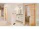 Bathroom featuring a vanity with ample storage, mirror, and an adjacent room with a window and sliding door at 3231 Oak St, Wheat Ridge, CO 80033