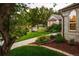 Exterior shot of home with manicured landscaping, large lawn and walkway to front door at 3231 Oak St, Wheat Ridge, CO 80033