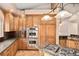 Gourmet kitchen featuring stainless steel appliances, double oven, cooktop, wood cabinetry, and granite countertops at 3231 Oak St, Wheat Ridge, CO 80033