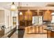 Spacious kitchen featuring warm wood cabinets, backsplash, granite countertops, and a kitchen island at 3231 Oak St, Wheat Ridge, CO 80033