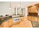 Large open kitchen with bar seating, stainless steel microwave, wood cabinets, and granite countertops at 3231 Oak St, Wheat Ridge, CO 80033