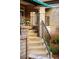 View of exterior porch with brick columns, iron railing, and steps with flowers at 3231 Oak St, Wheat Ridge, CO 80033