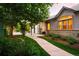 Exterior view of a home featuring a wrought-iron gate, landscaped yard, and a paved walkway at 3231 Oak St, Wheat Ridge, CO 80033