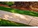 Concrete walkway through landscaped yard with mulch, grass, and lush bushes at 3231 Oak St, Wheat Ridge, CO 80033