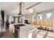 Open kitchen with island, stainless hood, modern lighting, and adjoining dining area at 4457 Wyandot St, Denver, CO 80211