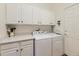Efficient laundry room featuring modern washer, dryer, and cabinetry at 17284 E Hawksbead Dr, Parker, CO 80134