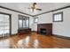 Bright living room with hardwood floors, a brick fireplace, and large windows, offering a comfortable and inviting space at 2933 Benton St, Wheat Ridge, CO 80214