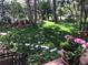 Landscaped backyard features a lush green lawn, flowers, trees, and a patio, perfect for relaxing at 19850 Indian Summer Ln, Monument, CO 80132