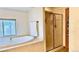 Bright bathroom featuring a soaking tub with a window view and a tiled glass shower at 19850 Indian Summer Ln, Monument, CO 80132
