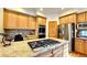 Spacious kitchen with wooden cabinets, stainless steel appliances, and a central island with a cooktop at 19850 Indian Summer Ln, Monument, CO 80132