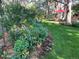 Landscaped yard with flowers, a garden, green grass, and mature trees around the backyard space at 19850 Indian Summer Ln, Monument, CO 80132