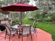Outdoor patio with umbrella, table, and chairs surrounded by a lush green lawn and mature trees at 19850 Indian Summer Ln, Monument, CO 80132