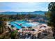 Aerial view of community pool, featuring multiple pools, water features, lounge chairs, and umbrellas at 19850 Indian Summer Ln, Monument, CO 80132