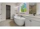 Luxurious bathroom with a soaking tub, double vanities, and views of the outdoors from a large window at 5909 S Platte Canyon Dr, Littleton, CO 80123