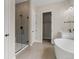 Bathroom featuring glass enclosed shower, soaking tub, and double door access to a walk-in closet at 5909 S Platte Canyon Dr, Littleton, CO 80123
