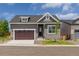 Charming home with a brown garage door and a green lawn at 5909 S Platte Canyon Dr, Littleton, CO 80123