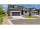 Home exterior with a two-car garage, manicured lawn, and modern design at 5909 S Platte Canyon Dr, Littleton, CO 80123
