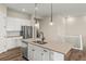 Open concept kitchen with stainless steel appliances, a center island with sink, and hardwood flooring at 5909 S Platte Canyon Dr, Littleton, CO 80123