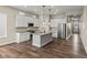 Modern kitchen with hardwood floors, white cabinets, stainless steel appliances, and a center island with bar seating at 5909 S Platte Canyon Dr, Littleton, CO 80123