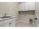 Laundry room featuring ample cabinet storage, a utility sink, and washer and dryer hookups at 5909 S Platte Canyon Dr, Littleton, CO 80123