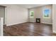 Cozy living room with hardwood floors, a fireplace, and large windows that provide ample natural light at 5909 S Platte Canyon Dr, Littleton, CO 80123