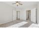 Bright bedroom featuring neutral carpeting, ceiling fan, and convenient ensuite bathroom access at 13598 Via Varra # 105, Broomfield, CO 80020