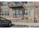 Condo building exterior with reserved parking featuring a private entryway and charming stone accents at 13598 Via Varra # 105, Broomfield, CO 80020