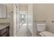 Hallway showcases a bathroom vanity with granite counters and leads to a sunlit bedroom at 13598 Via Varra # 105, Broomfield, CO 80020