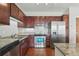 Stylish kitchen features granite counters, stainless steel appliances, dark wood cabinets, and tile backsplash at 13598 Via Varra # 105, Broomfield, CO 80020