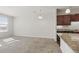 Open-concept living room featuring carpet and natural light, with a partial view of the kitchen at 13598 Via Varra # 105, Broomfield, CO 80020
