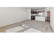 Spacious open-concept living room showcasing plush carpeting and a view of the modern kitchen at 13598 Via Varra # 105, Broomfield, CO 80020