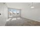Bright living room featuring carpet and natural light from the adjacent balcony door at 13598 Via Varra # 105, Broomfield, CO 80020